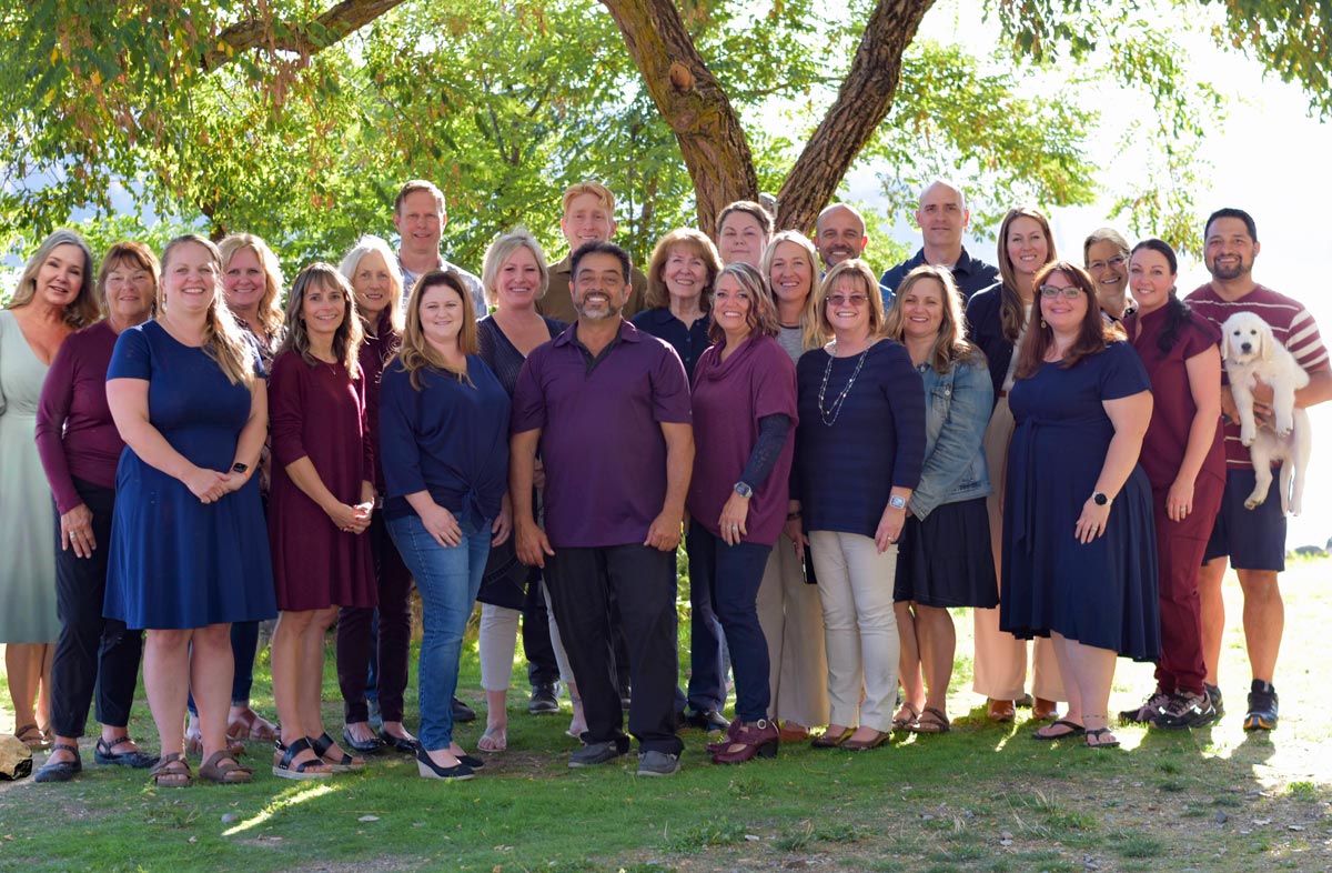 Group photo of the Reliant Healthcare Coeur d'Alene team, featuring healthcare professionals in uniform, smiling and standing together in an office setting.